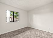 Thumbnail 10 of 30 - A room with a window and carpeted floor.