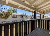 Thumbnail 21 of 35 - A wooden deck with a white roof and a view of a house and trees.