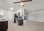 Thumbnail 8 of 35 - A modern kitchen with a stove, sink, and refrigerator.