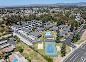 Thumbnail 22 of 35 - A tennis court is located in the middle of a parking lot.