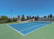 Thumbnail 27 of 35 - A tennis court with a blue surface and white lines.