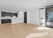 Thumbnail 60 of 119 - A spacious, modern kitchen with wooden floors and white walls.