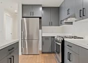 Thumbnail 91 of 119 - A modern kitchen with a stainless steel refrigerator and oven.