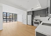 Thumbnail 31 of 119 - A modern kitchen with wooden floors and white appliances.