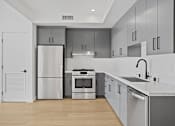 Thumbnail 32 of 119 - A modern kitchen with stainless steel appliances and wooden floors.