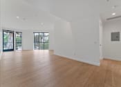 Thumbnail 94 of 119 - A large empty room with wooden floors and white walls.