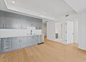Thumbnail 34 of 119 - A kitchen with white cabinets and a wooden floor.