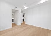 Thumbnail 67 of 119 - A room with a white wall and wooden flooring.