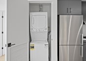 Thumbnail 37 of 119 - A white dishwasher is in a kitchen next to a refrigerator.