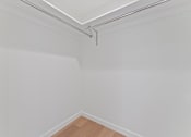 Thumbnail 103 of 119 - A white wall with a wooden floor and a metal pipe on the ceiling.
