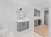 Thumbnail 64 of 119 - A white toilet is in a bathroom with a sink and mirror.