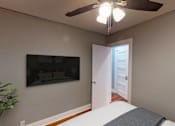 Thumbnail 20 of 21 - A room with a ceiling fan and a door leading to another room.