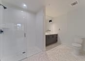 Thumbnail 92 of 119 - A white bathroom with a walk-in shower and a toilet.