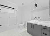 Thumbnail 62 of 119 - A white bathroom with a toilet, sink, and shower.