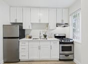Thumbnail 17 of 79 - A kitchen with white cabinets and appliances.