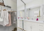 Thumbnail 14 of 79 - A bathroom with a white vanity and a mirror above it.