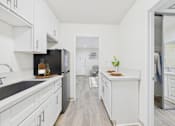 Thumbnail 9 of 79 - A kitchen with white cabinets and a black fridge.