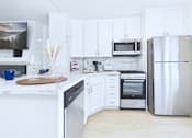 Thumbnail 40 of 49 - A kitchen with white cabinets and appliances.