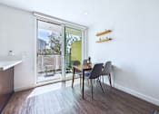 Thumbnail 20 of 49 - A dining room with a table and chairs and a sliding glass door.