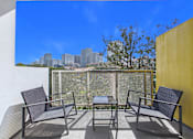 Thumbnail 25 of 49 - A patio with a table and chairs overlooking a city skyline.