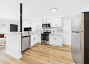 Thumbnail 5 of 32 - A modern kitchen with white cabinets and stainless steel appliances.