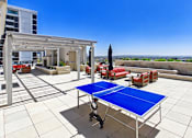 Thumbnail 53 of 56 - A blue table is in the middle of a white tiled patio.