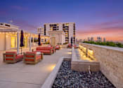 Thumbnail 55 of 56 - A rooftop patio with a water feature and seating area.