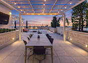 Thumbnail 50 of 56 - A patio with a table and chairs under a roof.