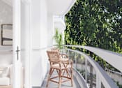 Thumbnail 7 of 53 - A wooden chair is on a balcony with a white railing.