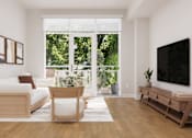 Thumbnail 5 of 53 - A living room with a white couch, a wooden chair, a wooden table, and a flat screen TV.