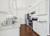 Thumbnail 1 of 29 - A kitchen with white cabinets and a marble countertop.
