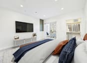 Thumbnail 4 of 44 - A modern living room with a grey sofa and a flat screen TV mounted on the wall.