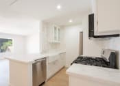 Thumbnail 6 of 28 - a white kitchen with a stove and a microwave