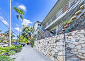 Thumbnail 12 of 16 - A stone wall runs along the side of a building.