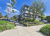 Thumbnail 13 of 16 - A modern two-story house with a grey exterior and a well-maintained garden in front.