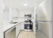 Thumbnail 16 of 115 - A modern kitchen with stainless steel appliances and white cabinetry.