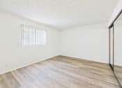 Thumbnail 21 of 115 - A room with wooden flooring and a window with blinds.