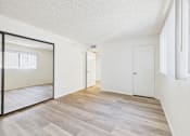 Thumbnail 22 of 115 - A room with a wooden floor and white walls.