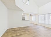 Thumbnail 19 of 115 - A spacious room with wooden flooring and a skylight.