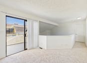 Thumbnail 24 of 115 - A large, empty room with a sliding glass door leading to a balcony.