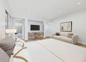 Thumbnail 6 of 49 - A modern living room with a white sofa and a television.