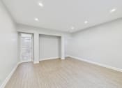 Thumbnail 45 of 49 - A large empty room with a doorway leading to a bathroom.