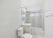 Thumbnail 48 of 49 - A white toilet sits next to a sink in a small bathroom.
