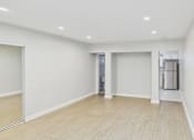Thumbnail 47 of 49 - A spacious room with a door and a trash can.