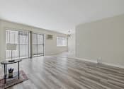 Thumbnail 50 of 67 - A room with wooden flooring and a table with a vase on it.