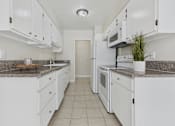Thumbnail 40 of 67 - A kitchen with white cabinets and appliances.
