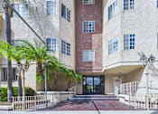 Thumbnail 13 of 17 - A building with a red brick wall and a glass door entrance.