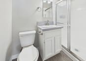 Thumbnail 47 of 49 - A white toilet sits next to a sink in a small bathroom.