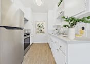 Thumbnail 44 of 49 - A kitchen with white cabinets and a stainless steel refrigerator.