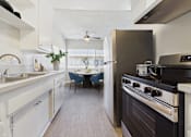 Thumbnail 41 of 49 - A modern kitchen with a black stove top oven.